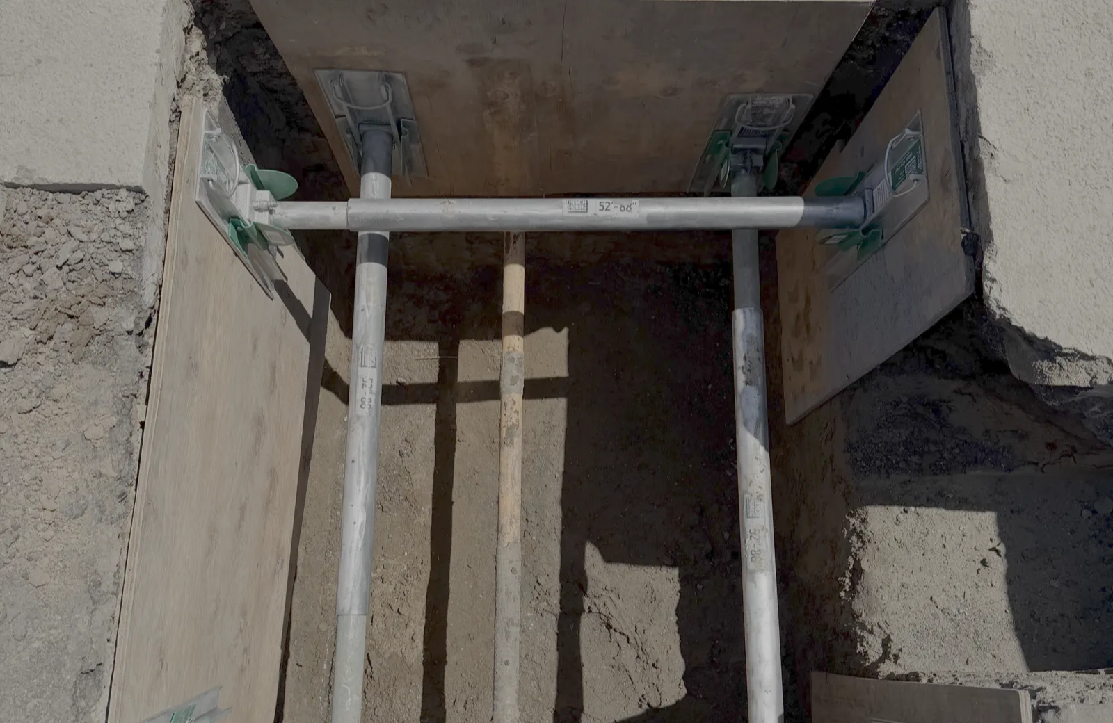 Hydraulic shoring and plywood set inside an excavation to OSHA and PG&E requirements for a gas mainline upgrade