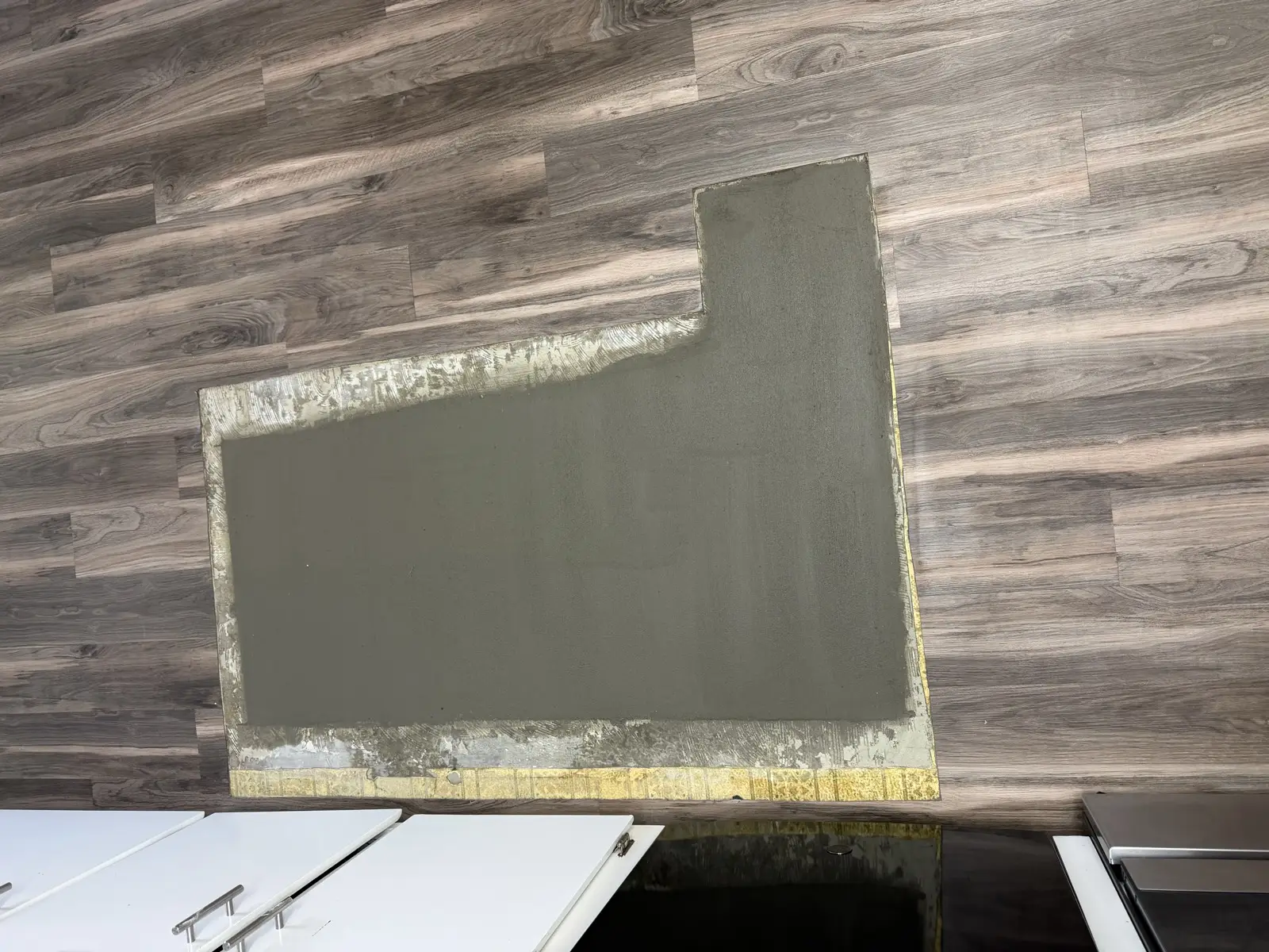 Close view of the finished concrete patch where the kitchen slab was cut for the drain line replacement
